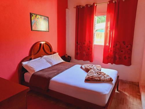 - une chambre avec un lit aux murs rouges et une fenêtre dans l'établissement Casa de Campo Pedra Bicuda, à Brazópolis