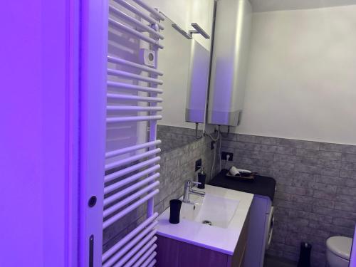 ein Bad mit einem Waschbecken und einem Spiegel in der Unterkunft FEEL - Vivid Apartment in Bergamo