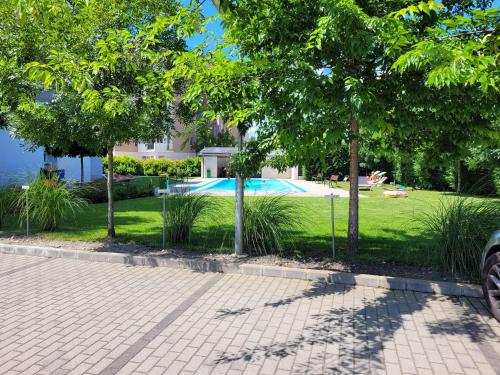 een park met een zwembad en bomen bij Solar Golden Beach Apartments in Siófok