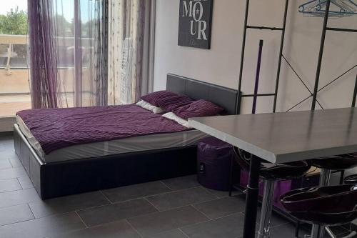 une petite chambre avec un lit et une table dans l'établissement Studio 77, Héliopolis L au village naturiste, au Cap d'Agde