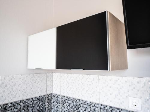 een flatscreen-tv boven een badkamerspiegel bij Pavlopetri in Vingláfia