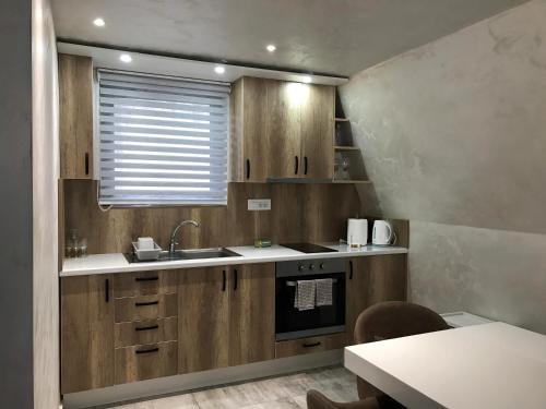a kitchen with wooden cabinets and a sink at Miletic Villas in Despotovac