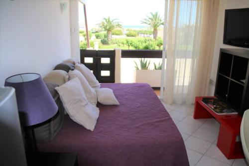 - une chambre avec un lit violet et des oreillers blancs dans l'établissement Studio 717, Port Nature 7 au village naturiste, au Cap d'Agde