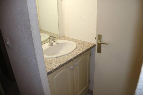 une salle de bain avec un lavabo et un miroir dans l'établissement Studio 717, Port Nature 7 au village naturiste, au Cap d'Agde