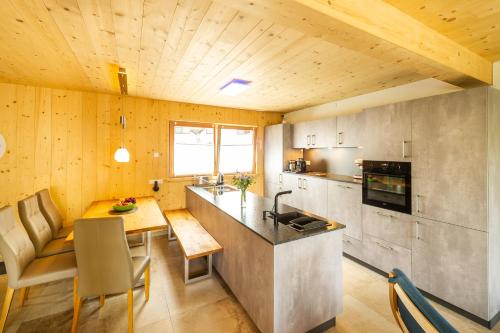 a kitchen and dining room with a table and a counter at Haus Regenbogen in Prägraten am Großvenediger