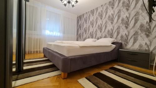 ein Schlafzimmer mit einem Bett und einer Wand in der Unterkunft Sarajevo City Deluxe Apartment in Sarajevo