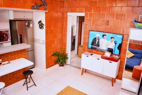 a kitchen with a flat screen tv on a brick wall at Barra da Tijuca Rio de Janeiro ilha da gigoia in Rio de Janeiro