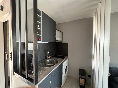 a small kitchen with a sink and a washing machine at L'Acropole in Cap d'Agde