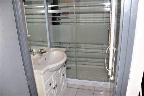 une salle de bain avec une douche en verre et un lavabo dans l'établissement Studio 321, Héliopolis AB au village naturiste, au Cap d'Agde