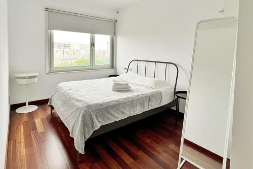a white bedroom with a bed and a window at Ral48 in Barcelona