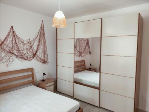 a bedroom with two beds and a mirrored closet at Appartamento Stella Marina in Senigallia