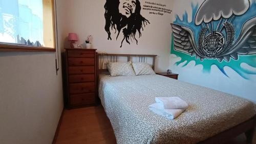 um quarto com uma cama com um quadro na parede em Palmeiras em Arcozelo