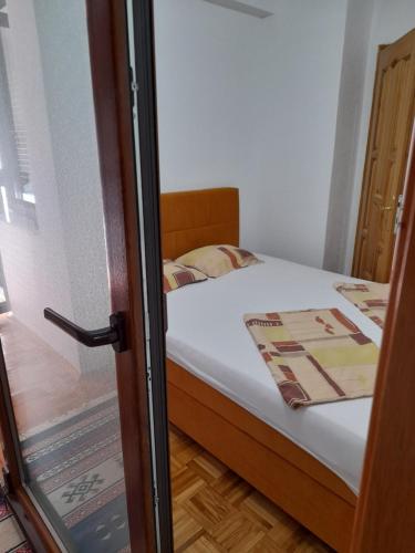 1 dormitorio pequeño con 1 cama con sábanas blancas en Apartman Insula, en Otoka