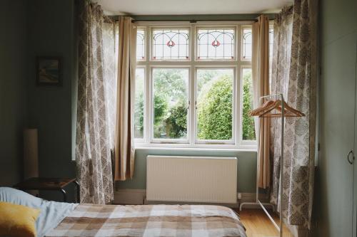 1 dormitorio con cama y ventana grande en A cosy garden flat in a quiet area close to the city centre en Bristol