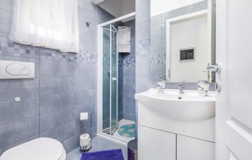 a white bathroom with a sink and a toilet at Apartment Jela in Fažana