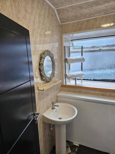 a bathroom with a sink and a mirror at Skyline king Studio room 201 in Swansea
