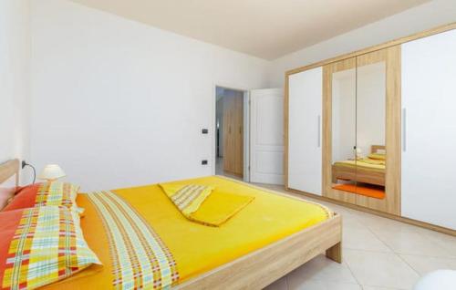 Un dormitorio con una gran cama amarilla y un espejo en Apartment Jela en Fažana