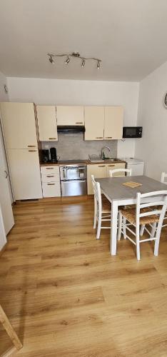une cuisine avec une table et des chaises dans une pièce dans l'établissement Villa Duchatel Appt 2/4 pers, à Le Mont-Dore