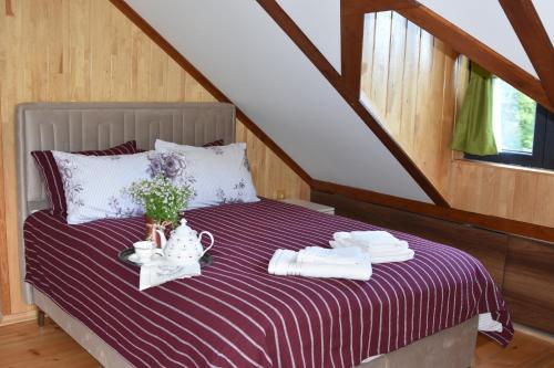 a bed with a purple and white striped blanket at ÇAYKARA-NANAGA 1883 Four bedroom villa in Çaykara