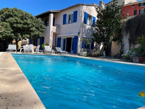 une piscine avec de l'eau bleue devant une maison dans l'établissement La Casane - Private Villa - Provence, à Carcès