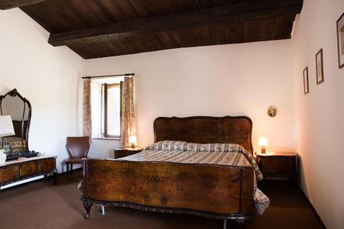 - une chambre avec un lit en bois et une fenêtre dans l'établissement Casale Fornello, à Acquapendente