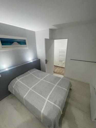 1 dormitorio con 1 cama en una habitación blanca en chambre etage fonctionnelle et independante, en Saucats
