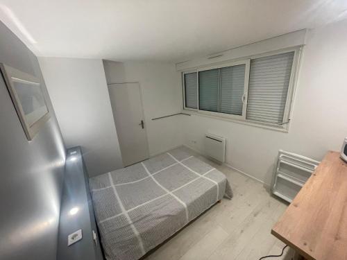 Habitación pequeña con cama y ventana en chambre etage fonctionnelle et independante, en Saucats