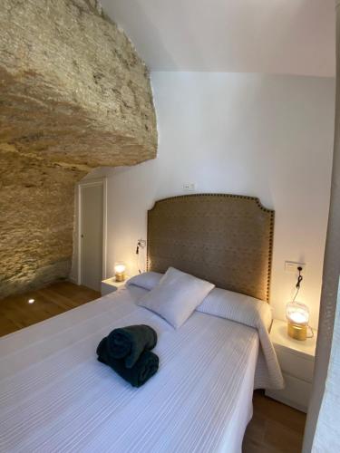 1 dormitorio con 1 cama grande con una roca grande en Casa Cueva “El Refugio en la Cueva”, en Setenil