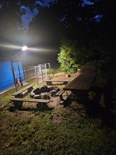 a picnic table in a field next to a fence at Eden nad Lubie Linowno in Linowo