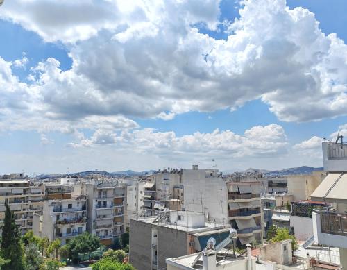a city under a cloudy sky with buildings at Funky Boho Kallithea Loft in Athens