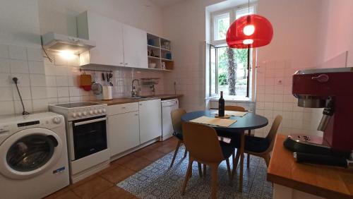 - une cuisine avec une table et un lave-linge dans l'établissement Apartment LAUREL Center Opatija, à Opatija