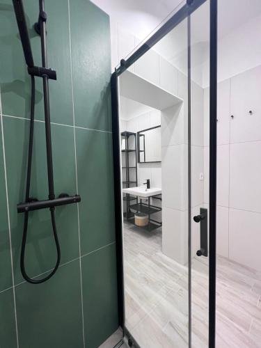 a glass shower door in a room with a table at Best Apartman Boglár in Balatonboglár