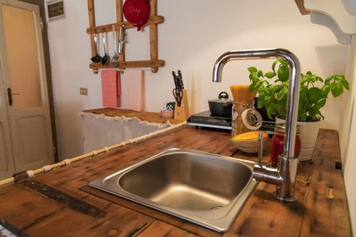 - un évier dans une cuisine avec un comptoir en bois dans l'établissement Leontine Home in Mondaino by Yohome, à Mondaino