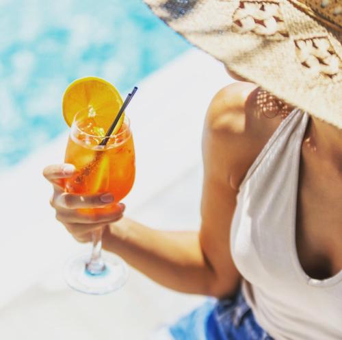 a woman holding a drink in her hand at Chill Out Studio in Mikonos