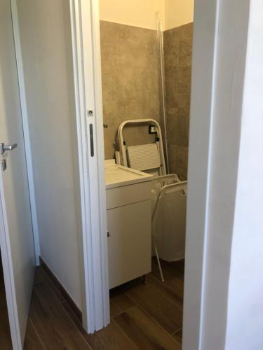 a bathroom with a sink and a chair next to a mirror at Le maioliche allo Stagnone kite in Marsala