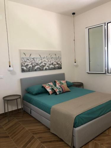 a bedroom with a bed and a painting on the wall at Le maioliche allo Stagnone kite in Marsala