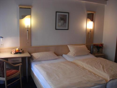 1 dormitorio con 2 camas, escritorio y 2 lámparas en Gasthaus Wiemann-Sander, en Bad Iburg