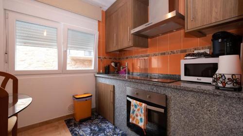 a kitchen with a counter and a microwave at Pisos A Barca in Muxia