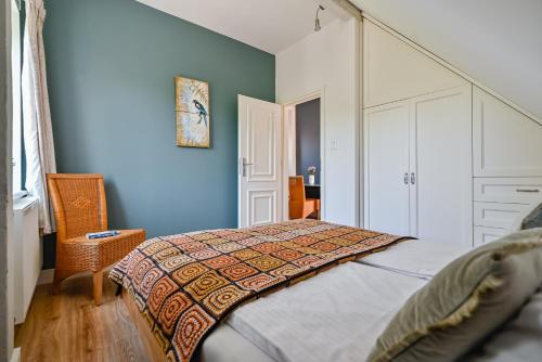 a bedroom with a bed and a blue wall at Villa Garden Boho in Olsztyn