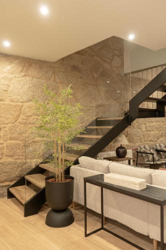 a living room with a staircase and a potted plant at Villa Mara in Villanueva de Arosa
