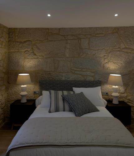 a bedroom with a large bed with two lamps at Villa Mara in Villanueva de Arosa
