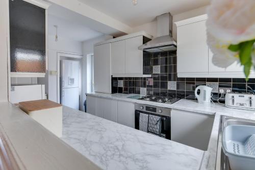 a kitchen with white cabinets and a counter top at Farmway lodge in Middleton