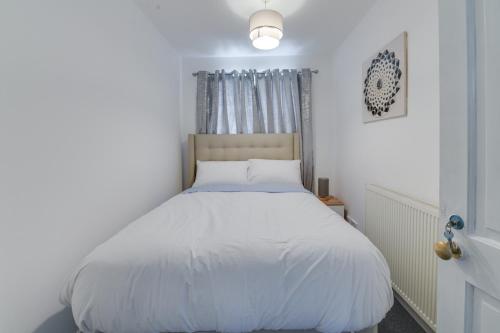 een slaapkamer met een wit bed en een raam bij Farmway lodge in Middleton