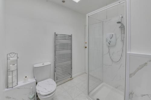 a white bathroom with a shower and a toilet at Farmway lodge in Middleton