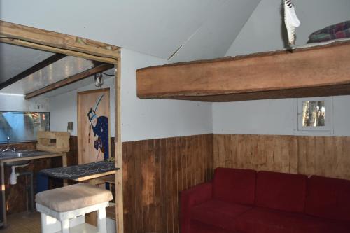 a living room with a red couch and a table at Refugio El Cauque in Puerto Williams