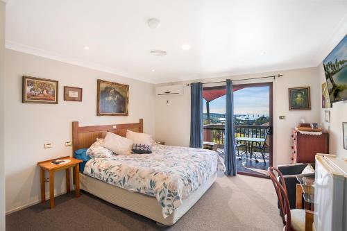 a bedroom with a bed and a balcony at Anchors Aweigh - Adult & Guests Only in Narooma