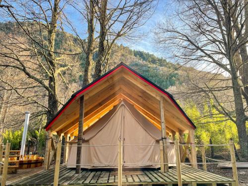 a small tent on a wooden deck in the woods at Casa del Árbol - Glamping in Malalcahuello