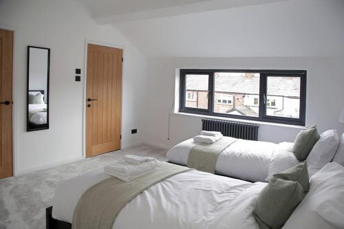 two white beds in a room with a window at Modern Luxury 4 Bed House in the Heart of Macclesfield in Macclesfield