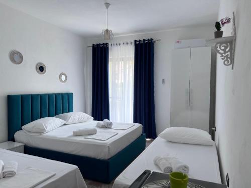a hotel room with two beds and a window at Mabel Rooms in Durrës