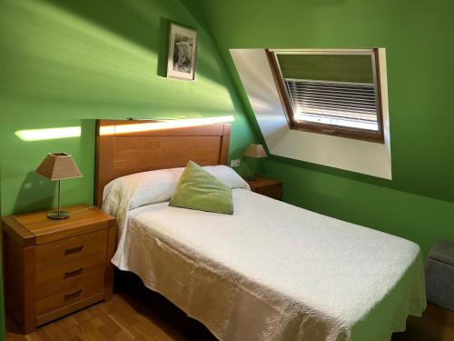 a green bedroom with two beds and a window at Vista puerto deportivo in Villanueva de Arosa